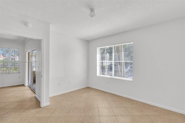 11643 W Atlantic Blvd Unit 1101, Coral Springs, FL 33071 - empty room featuring light tile patterned floors, a textured ceiling, baseboards, and a smoke detector