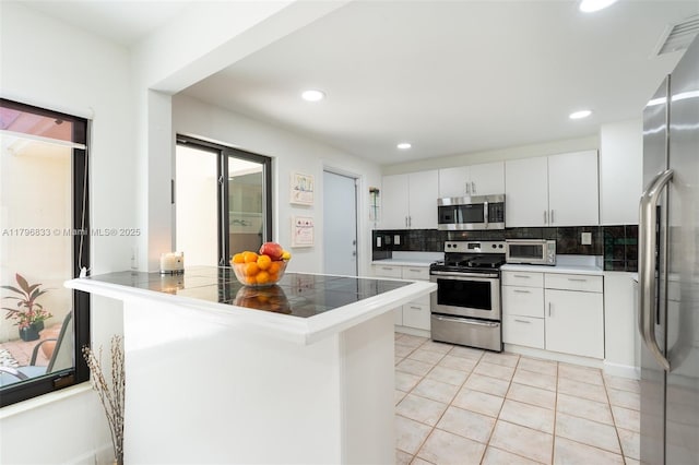 3620 E Forge Rd Unit 16, Davie, FL 33328 - kitchen featuring stainless steel appliances, backsplash, a peninsula, white cabinets, and light tile patterned floors