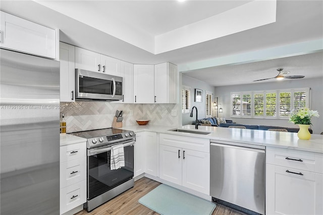 1779 NE 39th Ct Unit 1107, Pompano Beach, FL 33064 - kitchen with stainless steel appliances, a sink, light countertops, backsplash, and white cabinets
