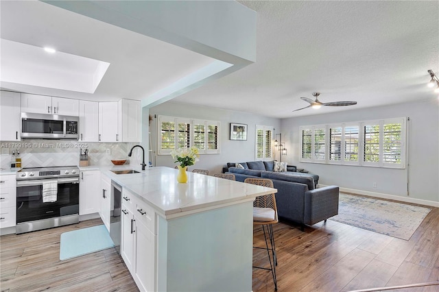 1779 NE 39th Ct Unit 1107, Pompano Beach, FL 33064 - kitchen with stainless steel appliances, a sink, light countertops, backsplash, and white cabinets