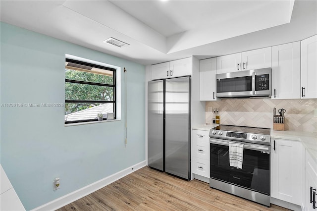 1779 NE 39th Ct Unit 1107, Pompano Beach, FL 33064 - kitchen with appliances with stainless steel finishes, decorative backsplash, light wood-type flooring, baseboards, and white cabinetry