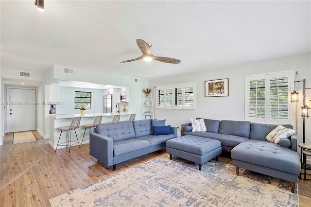 1779 NE 39th Ct Unit 1107, Pompano Beach, FL 33064 - living area featuring plenty of natural light, light wood-style flooring, a ceiling fan, and a textured ceiling