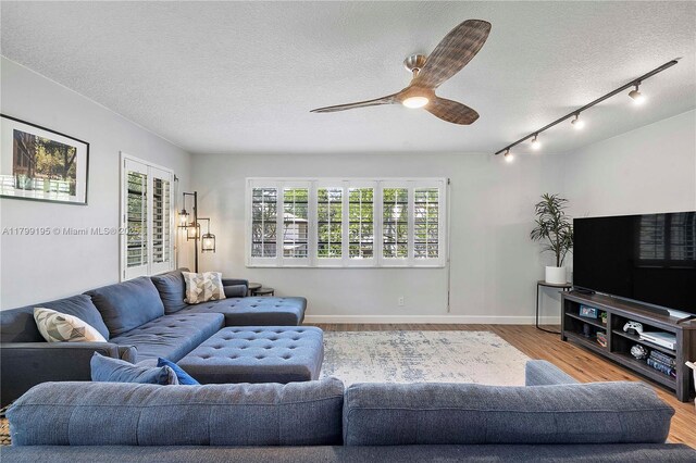 1779 NE 39th Ct Unit 1107, Pompano Beach, FL 33064 - living room featuring a textured ceiling, wood finished floors, track lighting, ceiling fan, and baseboards
