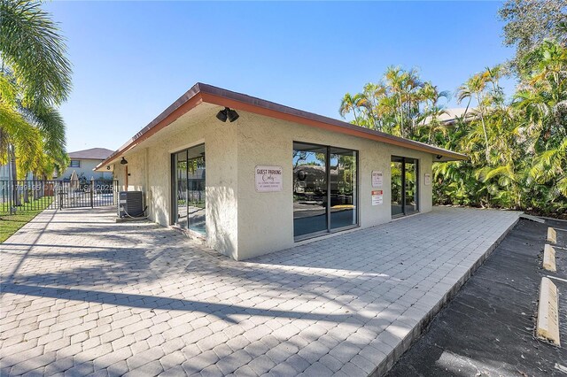 1779 NE 39th Ct Unit 1107, Pompano Beach, FL 33064 - back of house featuring stucco siding, cooling unit, and a patio area