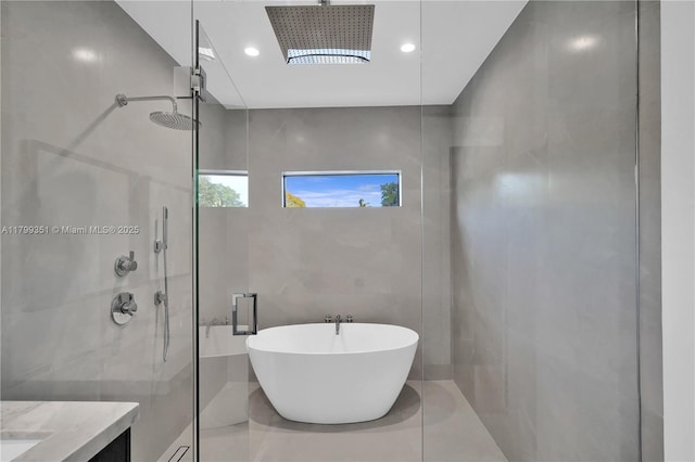 30 NE 50th St, Miami, FL 33137 - full bath featuring a tile shower, a soaking tub, tile walls, recessed lighting, and vanity