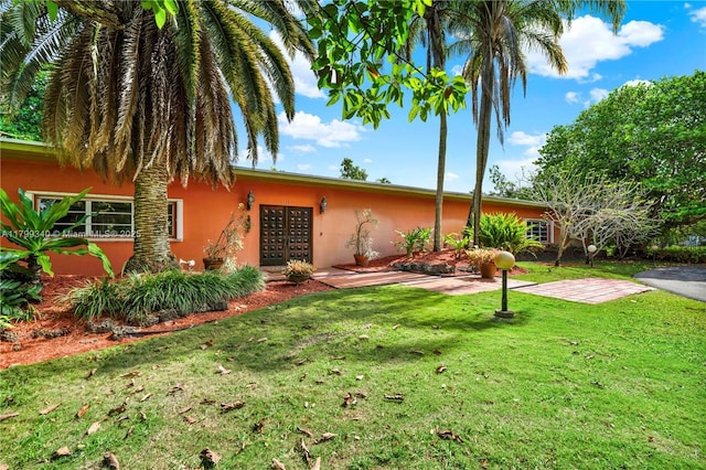 view of front of home with stucco siding and a front yard