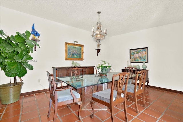 tiled dining area featuring baseboards, a chandelier, and a textured ceiling