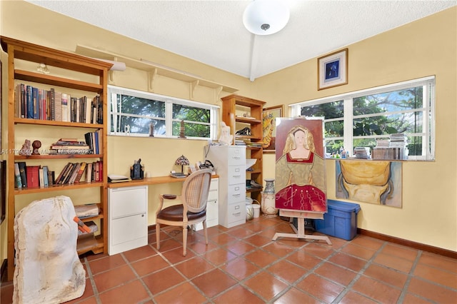 home office with plenty of natural light, a textured ceiling, and baseboards