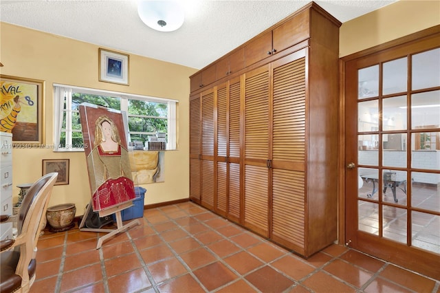 sitting room with baseboards, a textured ceiling, and tile patterned floors
