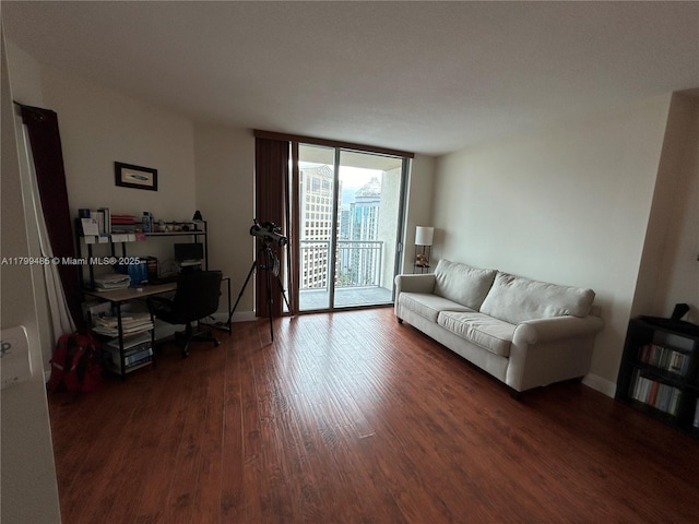 living room with wood finished floors, baseboards, floor to ceiling windows, and a desk