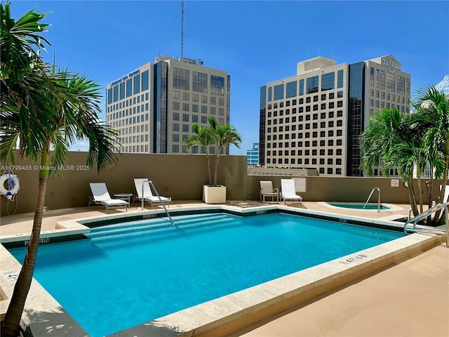 community pool with fence, a patio, and a community hot tub