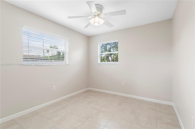 spare room featuring plenty of natural light, baseboards, and a ceiling fan