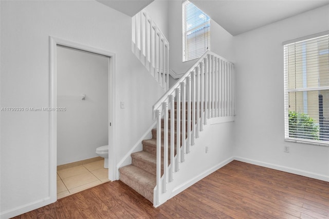 stairs with wood finished floors and baseboards