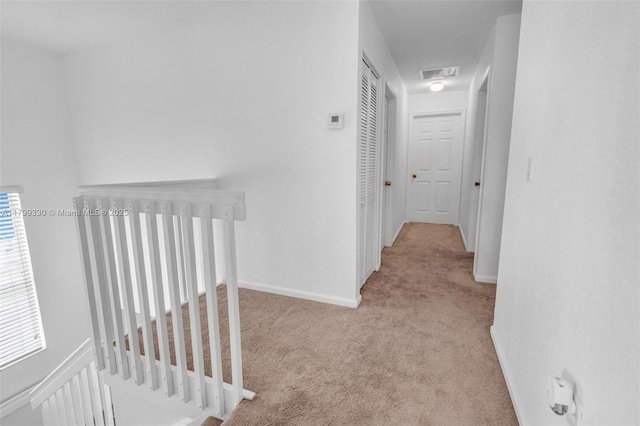 hallway featuring carpet and baseboards