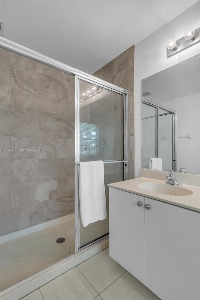 full bath with a shower stall, tile patterned floors, and vanity
