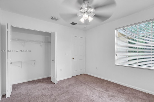 unfurnished bedroom with carpet floors, a closet, baseboards, and ceiling fan