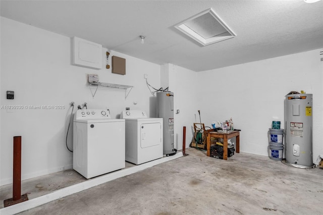 clothes washing area with electric water heater, independent washer and dryer, and attic access