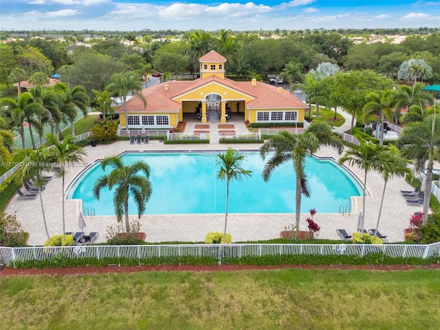 community pool featuring fence and view of wooded area