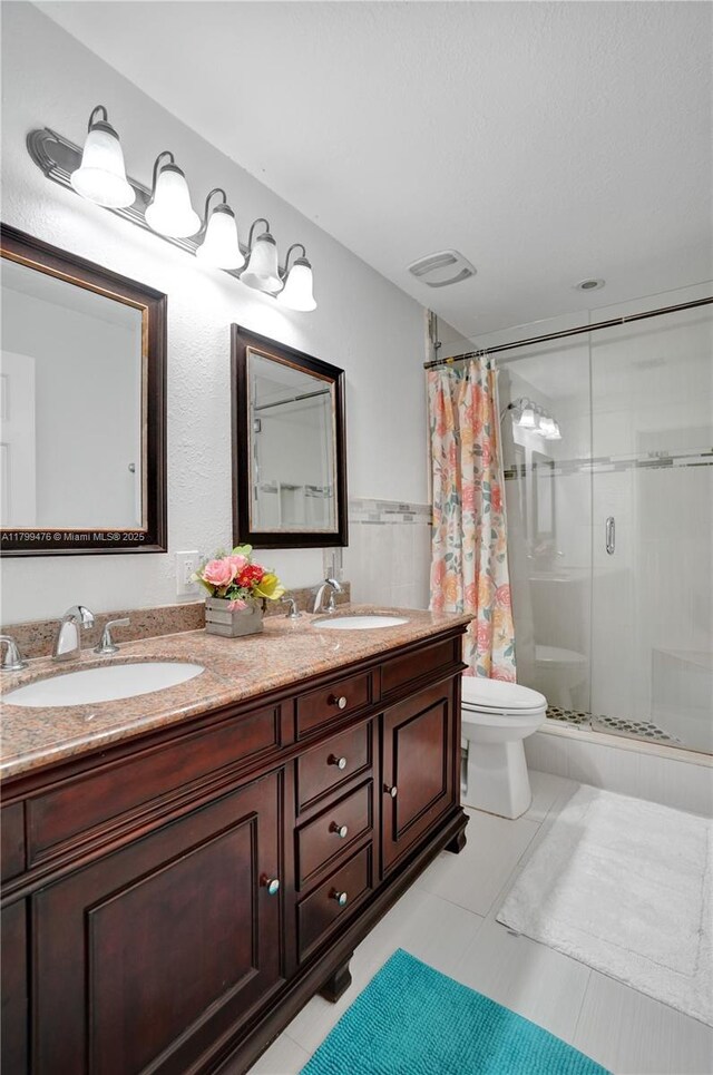 5354 NW 119th Ter, Coral Springs, FL 33076 - bathroom featuring a stall shower, toilet, double vanity, a wainscoted wall, and tile walls