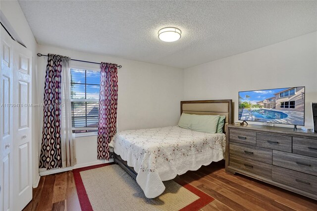 5354 NW 119th Ter, Coral Springs, FL 33076 - bedroom featuring dark wood-style flooring, a textured ceiling, and baseboards