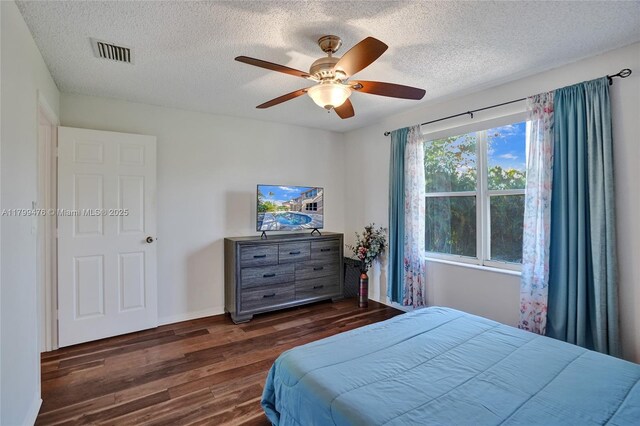 5354 NW 119th Ter, Coral Springs, FL 33076 - bedroom featuring dark wood-type flooring, a textured ceiling, a ceiling fan, and baseboards