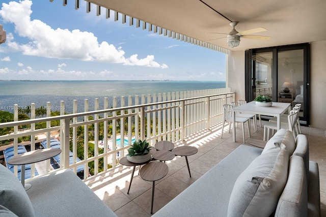 balcony with a ceiling fan, a water view, outdoor lounge area, and view of pool area