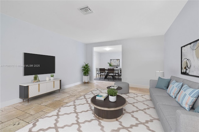 living area featuring stone tile floors and baseboards