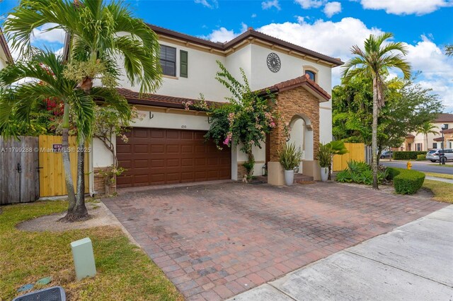 655 SE 37th Ter, Homestead, FL 33033 - mediterranean / spanish-style home featuring stone siding, stucco siding, a garage, and decorative driveway