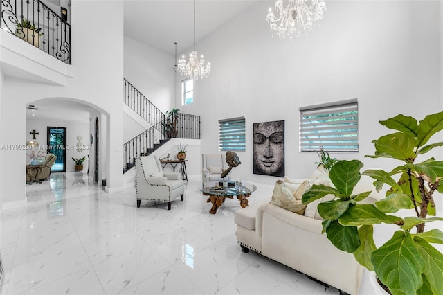 655 SE 37th Ter, Homestead, FL 33033 - living room featuring a chandelier, a towering ceiling, arched walkways, marble tiled flooring, and stairs