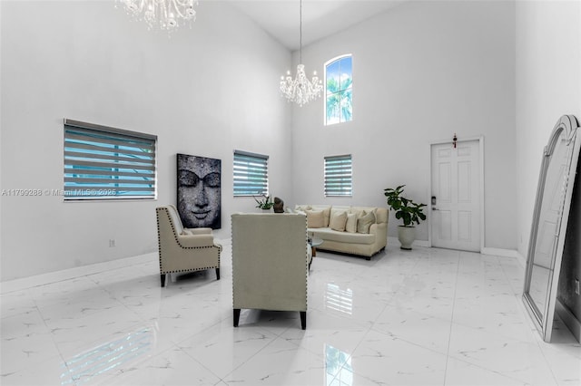 655 SE 37th Ter, Homestead, FL 33033 - living room featuring a chandelier, light marble finish flooring, a high ceiling, and baseboards
