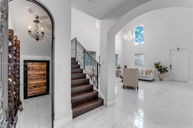 655 SE 37th Ter, Homestead, FL 33033 - foyer entrance featuring a chandelier, marble tiled flooring, arched walkways, stairway, and a high ceiling