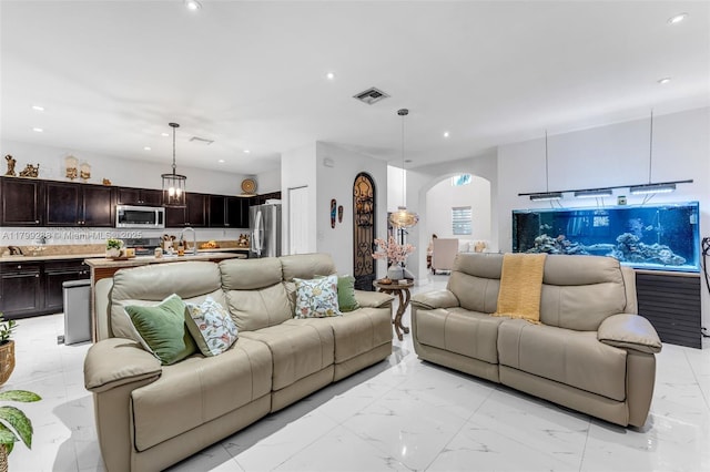 655 SE 37th Ter, Homestead, FL 33033 - living area featuring arched walkways, light marble finish floors, and recessed lighting