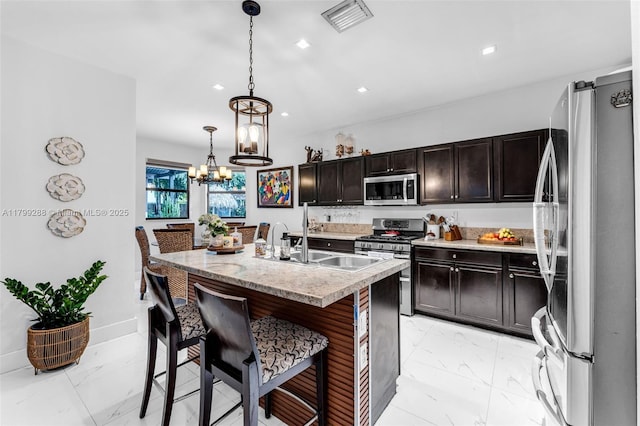 655 SE 37th Ter, Homestead, FL 33033 - kitchen with appliances with stainless steel finishes, light marble finish flooring, a chandelier, a kitchen breakfast bar, and recessed lighting