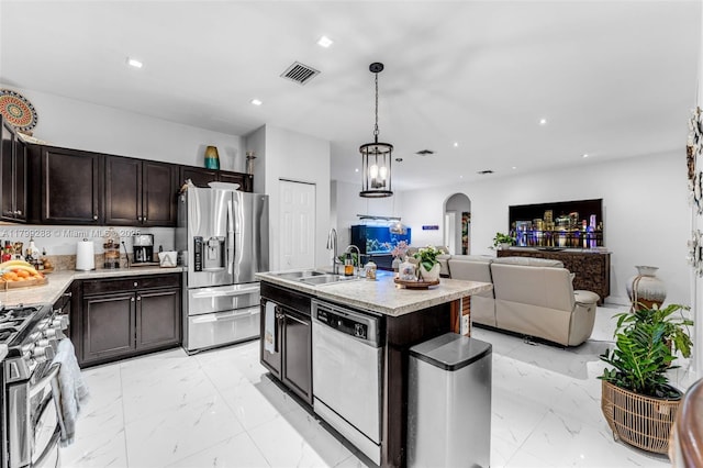 655 SE 37th Ter, Homestead, FL 33033 - kitchen with appliances with stainless steel finishes, a sink, arched walkways, light marble finish floors, and dark brown cabinetry