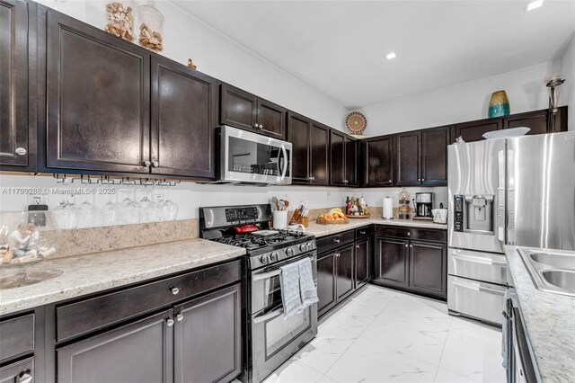 655 SE 37th Ter, Homestead, FL 33033 - kitchen featuring appliances with stainless steel finishes, light marble finish floors, and dark brown cabinetry