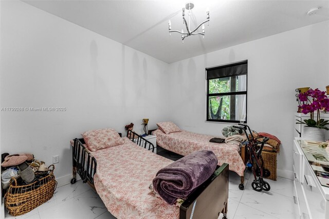 655 SE 37th Ter, Homestead, FL 33033 - bedroom with light marble finish floors, a chandelier, and baseboards