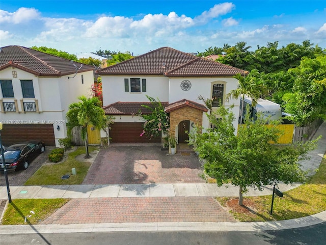 655 SE 37th Ter, Homestead, FL 33033 - mediterranean / spanish home with a garage, a tile roof, decorative driveway, stucco siding, and fence