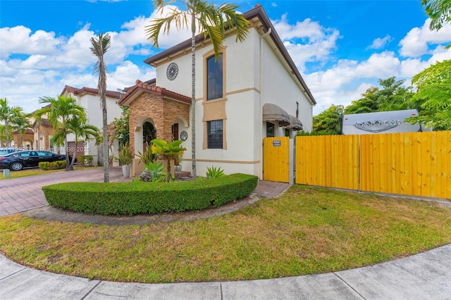 655 SE 37th Ter, Homestead, FL 33033 - view of property exterior with stucco siding, a gate, curved driveway, a tile roof, and stone siding