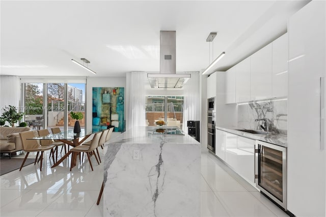 300 Sunny Isles Blvd Unit 4-501, Sunny Isles Beach, FL 33160 - kitchen featuring wine cooler, modern cabinets, white cabinetry, light stone counters, and backsplash