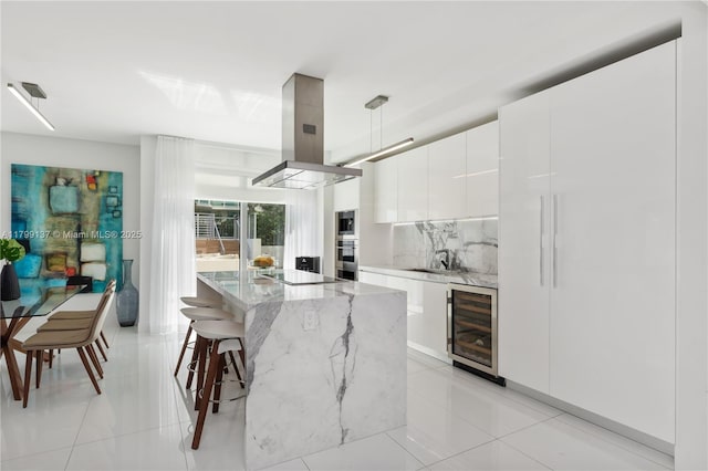 300 Sunny Isles Blvd Unit 4-501, Sunny Isles Beach, FL 33160 - kitchen featuring wine cooler, island exhaust hood, modern cabinets, oven, and tasteful backsplash