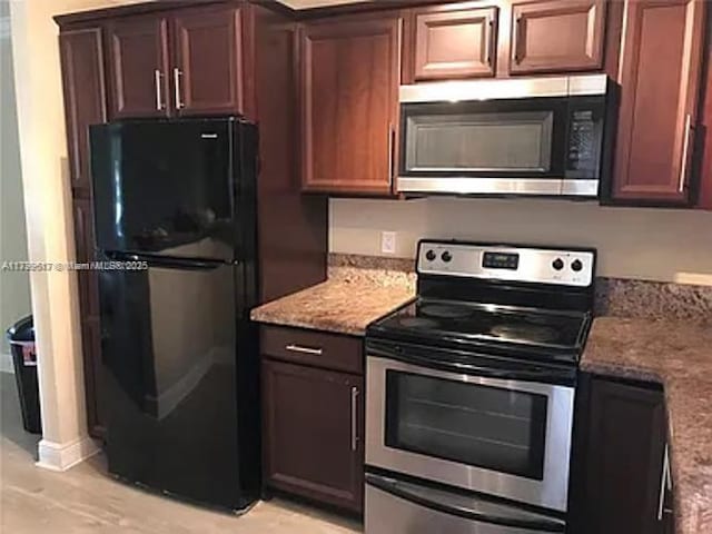 3361 NW 85th Ave Unit 201, Coral Springs, FL 33065 - kitchen featuring appliances with stainless steel finishes, light stone countertops, and baseboards