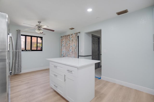 216 San Remo Blvd, North Lauderdale, FL 33068 - kitchen with freestanding refrigerator, light wood-type flooring, ceiling fan, white cabinetry, and baseboards