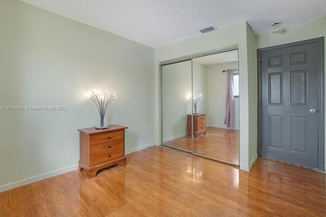 216 San Remo Blvd, North Lauderdale, FL 33068 - unfurnished bedroom with a closet, light wood-style flooring, a textured ceiling, and baseboards