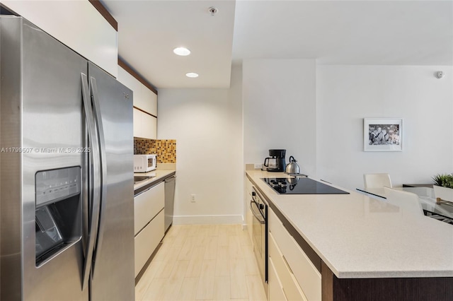 2155 Washington Unit 401, Miami Beach, FL 33139 - kitchen with stainless steel appliances, a peninsula, light countertops, modern cabinets, and white cabinetry