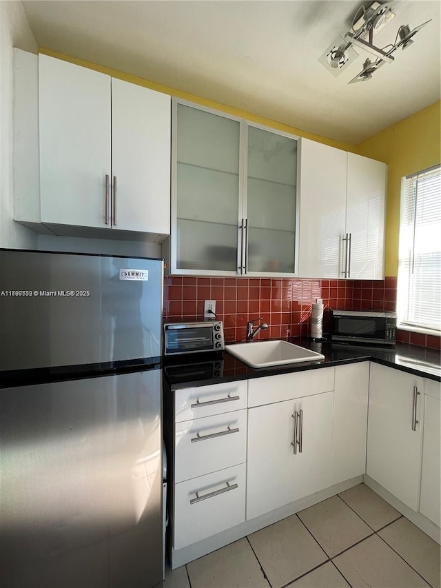 1051 Euclid Ave Unit 208, Miami Beach, FL 33139 - kitchen featuring appliances with stainless steel finishes, a sink, white cabinets, and tasteful backsplash