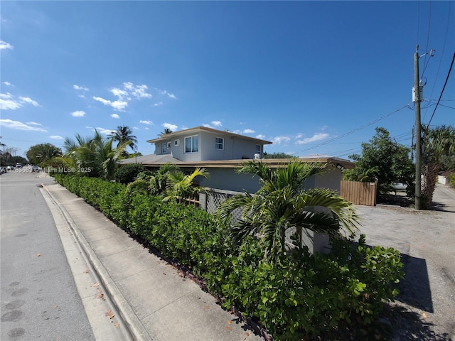 view of front facade with fence and stucco siding