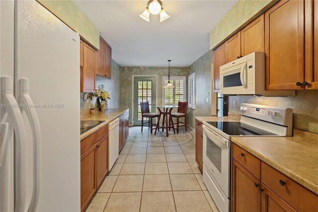 3568 Quail Trl, Melbourne, FL 32935 - kitchen featuring white appliances, brown cabinets, light tile patterned flooring, light countertops, and pendant lighting