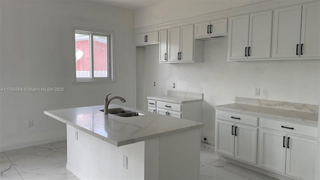 640 SW 12th Ave, Homestead, FL 33030 - kitchen with light marble finish flooring, a kitchen island with sink, white cabinets, and light stone countertops