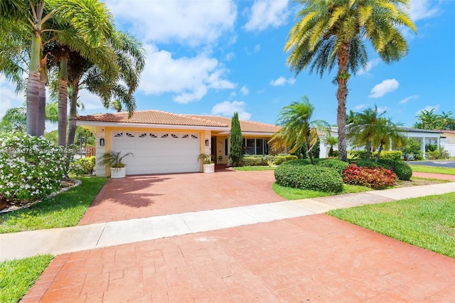 5221 Roosevelt St, Hollywood, FL 33021 - view of front of property with a tiled roof, decorative driveway, an attached garage, and stucco siding