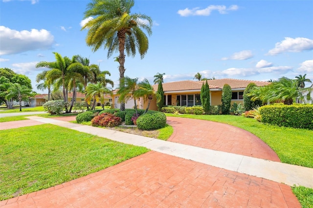 5221 Roosevelt St, Hollywood, FL 33021 - view of front of house with curved driveway, a front lawn, a tiled roof, and stucco siding